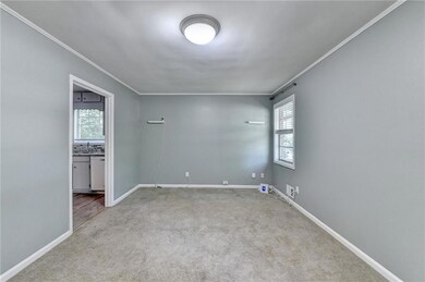Carpeted spare room featuring crown molding and ba