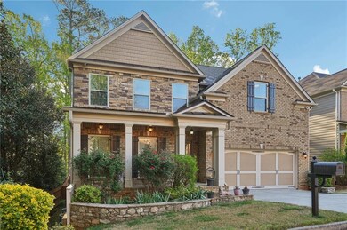 Craftsman inspired home featuring brick siding, an attached garage, driveway, and a porch