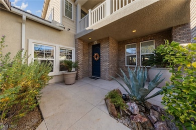 Property entrance featuring a balcony, brick sidin