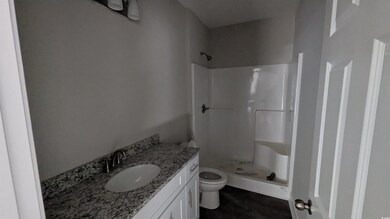 Full bathroom with a shower stall, toilet, and vanity
