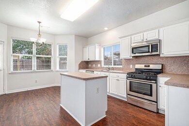 Bright kitchen with white cabinetry, stainless ste