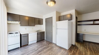 Kitchen with dark brown cabinets, dark hardwood /