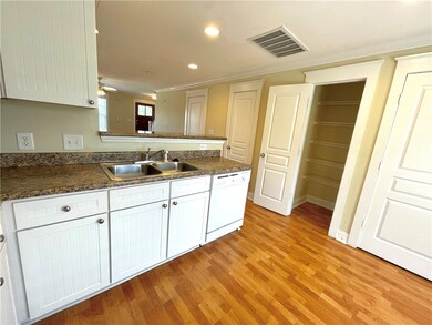 Kitchen featuring sink, dishwasher, white cabinetr