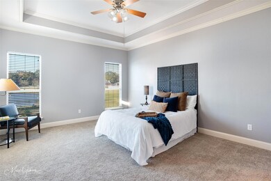 Primary bedroom with ceiling fan, ornamental moldi