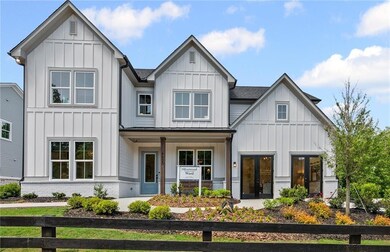 Modern farmhouse featuring board and batten siding, a porch, and a shingled roof