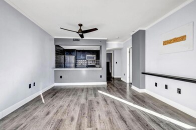 Unfurnished living room with ceiling fan, ornamental molding, and hardwood / wood-style floors