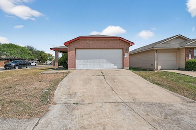View of front of home with driveway, brick siding, a front lawn, and a garage