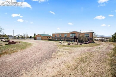 View of front of home featuring a garage and an ou