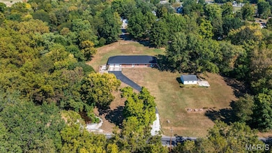 Aerial view of property and surrounding area featuring a forest
