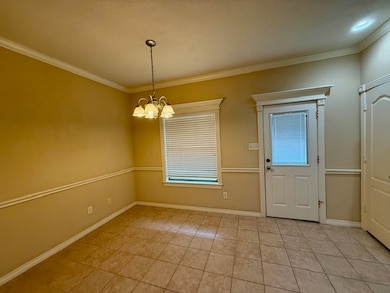 Unfurnished dining area featuring ornamental molding, a chandelier, light tile patterned floors, and healthy amount of natural light