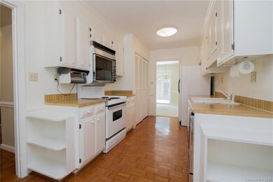 Galley style kitchen with built-in bookcases and p
