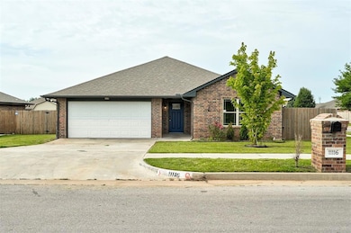 View of front of house with brick siding, driveway, roof with shingles, and a garage