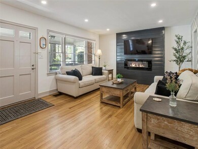Living room featuring light wood-style floors, a large fireplace, recessed lighting, and baseboards