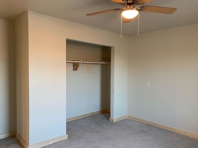 Unfurnished bedroom with concrete flooring, a clos