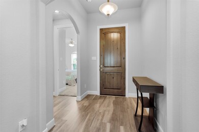 Wood front door opens into entry hall