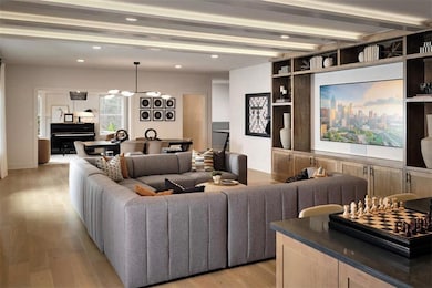 Living area with light wood-style floors, beam cei