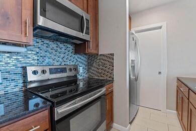 Kitchen with stainless steel appliances, dark sto