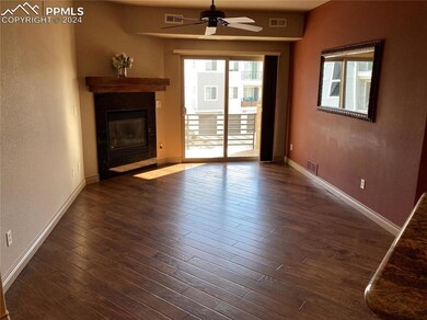 Spacious living room with ceiling fan, gas firepla