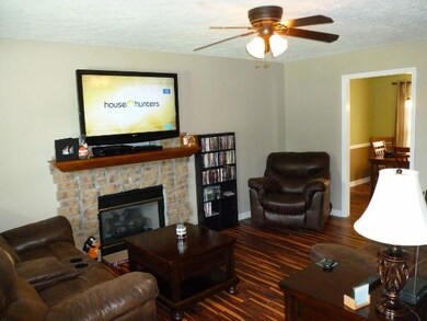 Living area with new floors, fixtures, and fireplace work.