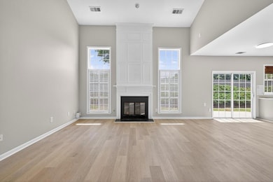 Unfurnished living room with light wood-style floors and a large fireplace