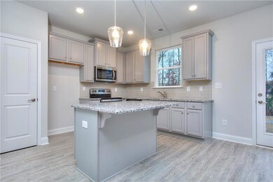 Kitchen with appliances with stainless steel finishes, gray cabinetry, light wood finished floors, tasteful backsplash, and recessed lighting