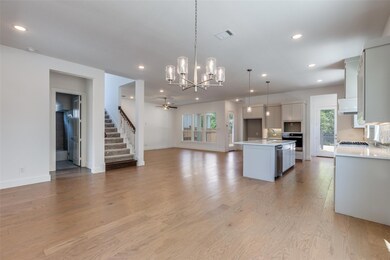 Kitchen featuring white cabinetry, hanging light f