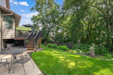 Mature trees and thoughtful landscaping surround the deck and patio.