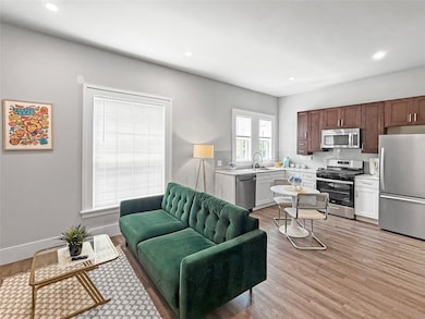 Living area with light wood-style floors and recessed lighting