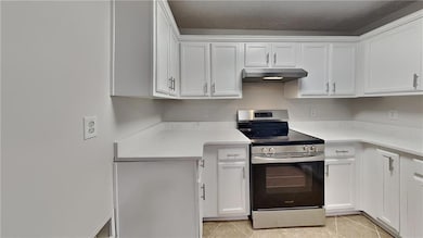Kitchen with light countertops, white cabinetry, u