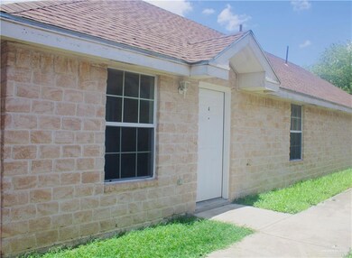 Property entrance with roof with shingles and brick siding