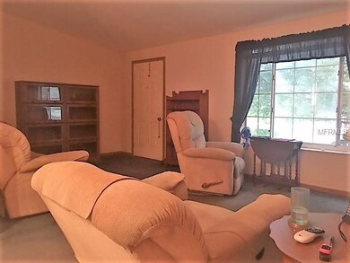 Living room is enhanced with vaulted ceilings.