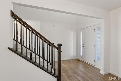 Entrance foyer with light wood-type flooring and stairway