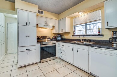 Kitchen with dark countertops, under cabinet range