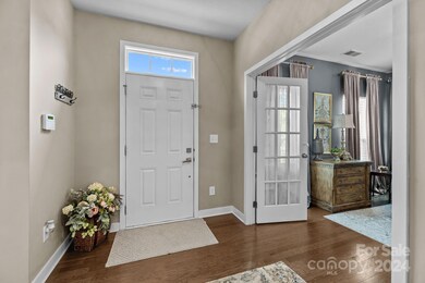Welcoming foyer with French doors opening to Office. Across the hallway is the Powder Room, coat closet, and Laundry Room.