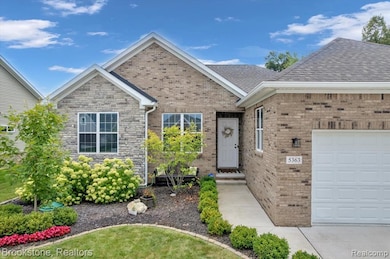 View of front of property featuring an attached garage and brick siding