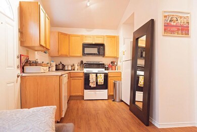 Kitchen with light wood finished floors, white ap