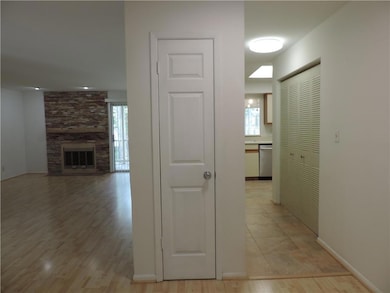 Corridor featuring plenty of natural light, light wood-type flooring, and baseboards
