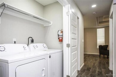 Washroom featuring washing machine and dryer, dark wood-type flooring, baseboards, and recessed lighting