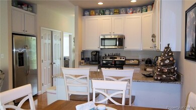 Kitchen with stone counters, sink, white cabinets,