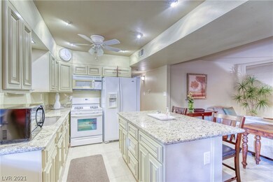 Island kitchen featuring granite counters, custom