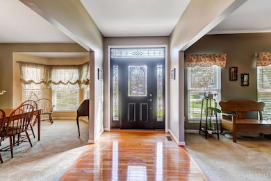 Entryway features wood flooring and WW in the dining room and office.
