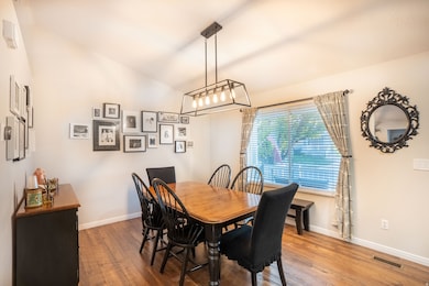 Dining space featuring lofted ceiling and wood floors