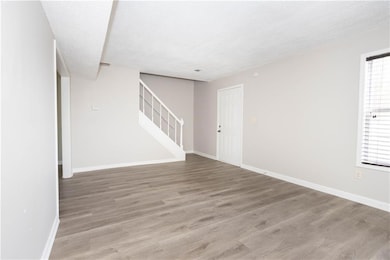 Unfurnished room with stairway, wood finished floo