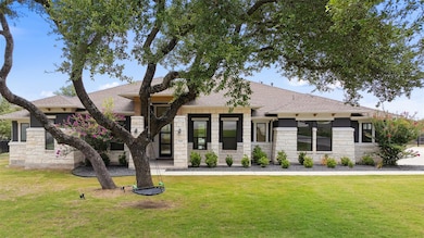 View of front of home featuring stone siding, a f