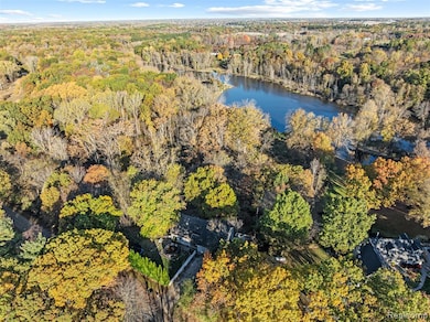 Drone / aerial view of a heavily wooded area and a nearby body of water
