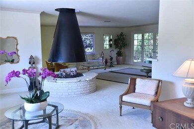 The circular fireplace is located between the livi
