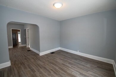 living room with large opening into dining room