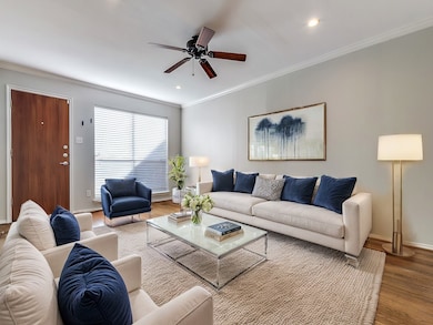 Living room with ornamental molding, hardwood / wood-style floors, and ceiling fan
