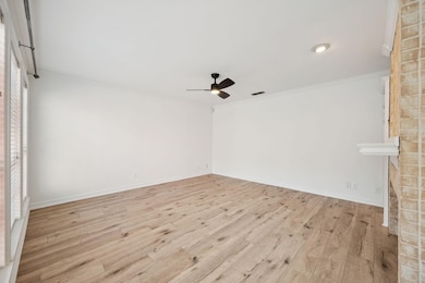 Spare room with light wood-style flooring, ornamental molding, and ceiling fan