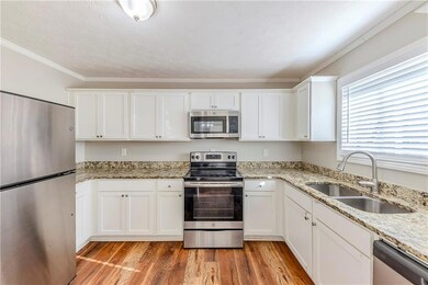 Kitchen with stainless steel appliances, light woo
